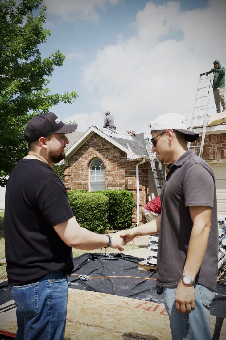 Prestige team members shaking hands on a job site